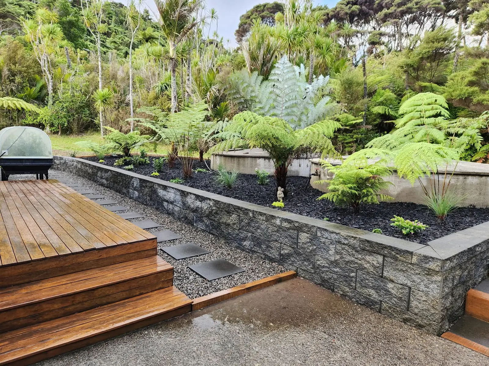 Timber deck, stone retaining wall and planted garden in West Auckland