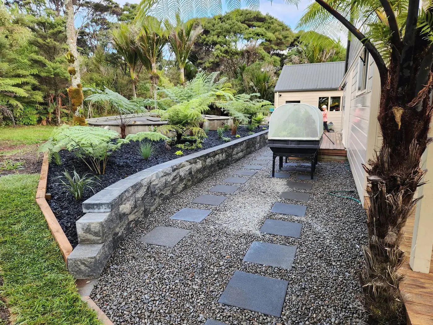 Stone paved pathway through a planted West Auckland garden